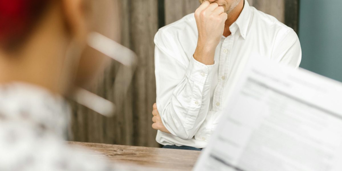 A person showing visible stress during a job interview, symbolizing the potential impact of algorithmic bias on career opportunities.