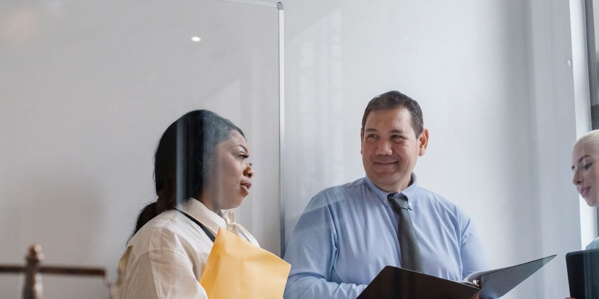 A team of professionals discusses regulatory documents, collaborating to understand complex compliance requirements.