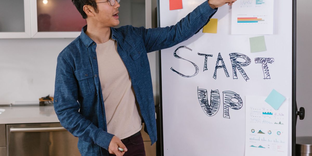 A person at a whiteboard explaining a complex concept to a small group.