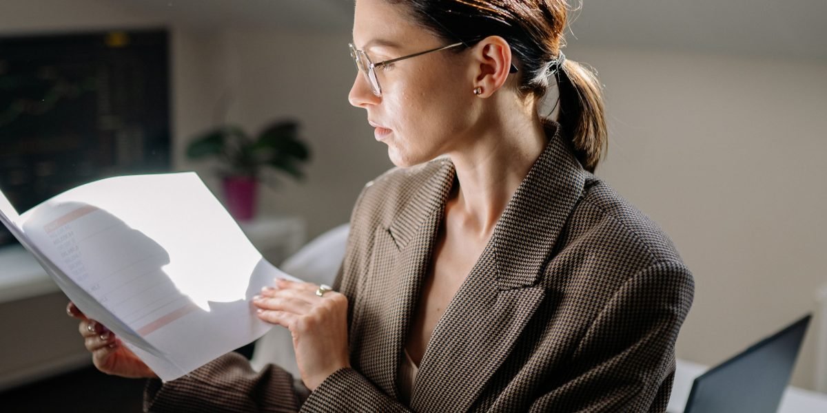 A professional meticulously reviewing a complex blueprint or detailed plan, focusing on intricate components.