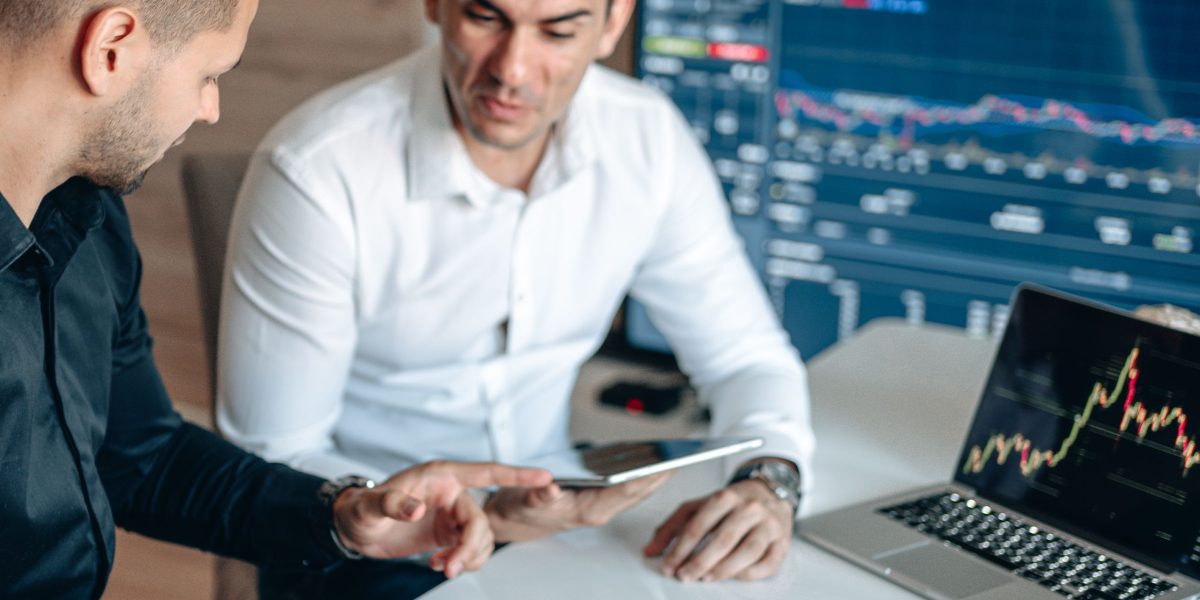 Two financial professionals reviewing market data and discussing investment strategies for AI startups in a regulated environment.