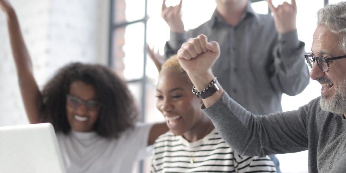 A team celebrates achieving a compliance milestone or project success, powered by AI tools and demonstrating clear ROI.