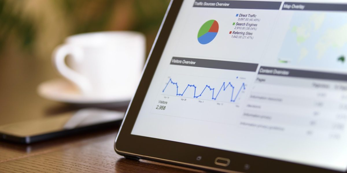 A business professional analyzing performance charts and graphs on a tablet, focused on key metrics.