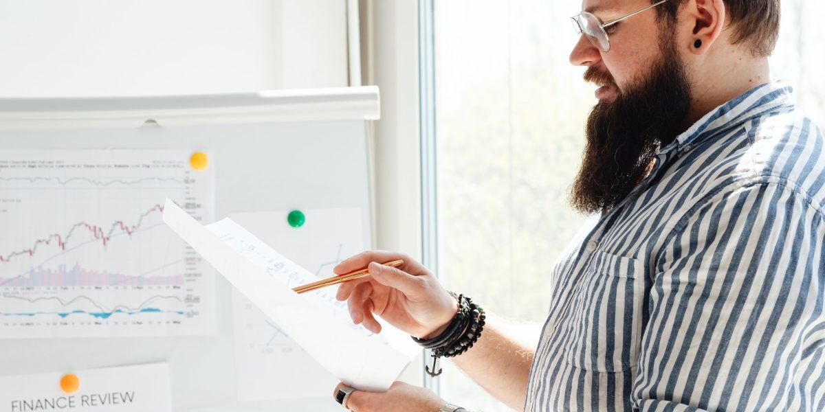 A business leader meticulously analyzes a financial report, reflecting the significant financial impacts of regulatory changes and market shifts.