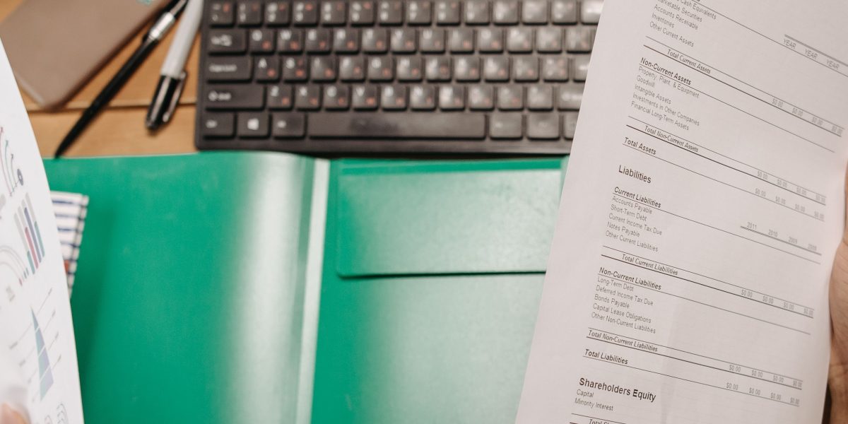 A person intently reviewing documents, reflecting the challenge of navigating and mapping complex regulatory landscapes.