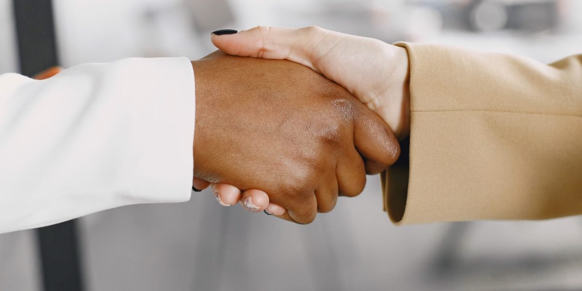 Two individuals shaking hands, symbolizing the establishment of trust and a collaborative relationship.