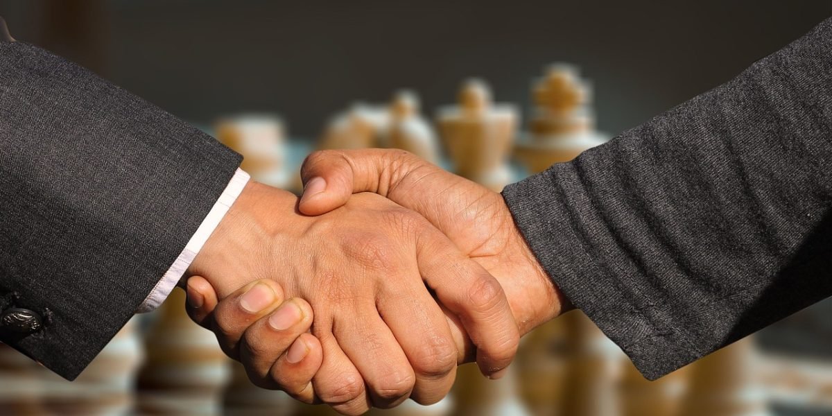 Professionals engaged in a serious discussion, negotiating and finalizing a business agreement.