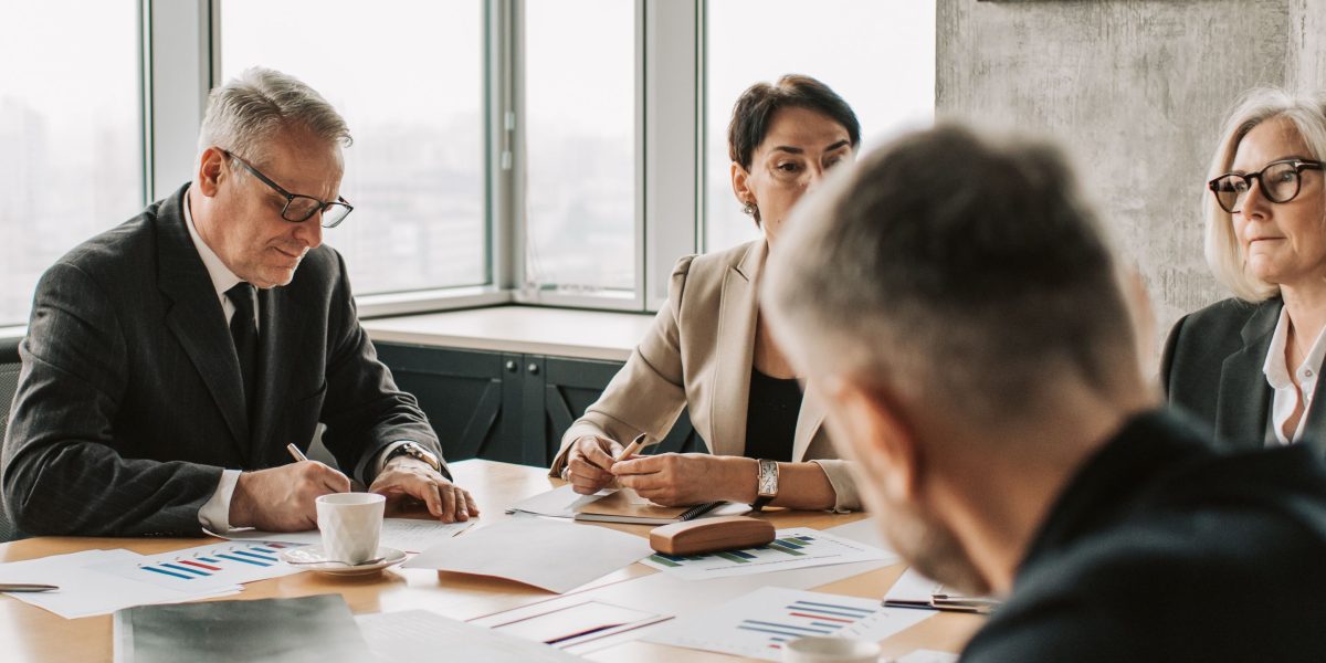 Business professionals in a meeting room, intensely discussing complex regulatory documents and compliance strategies.