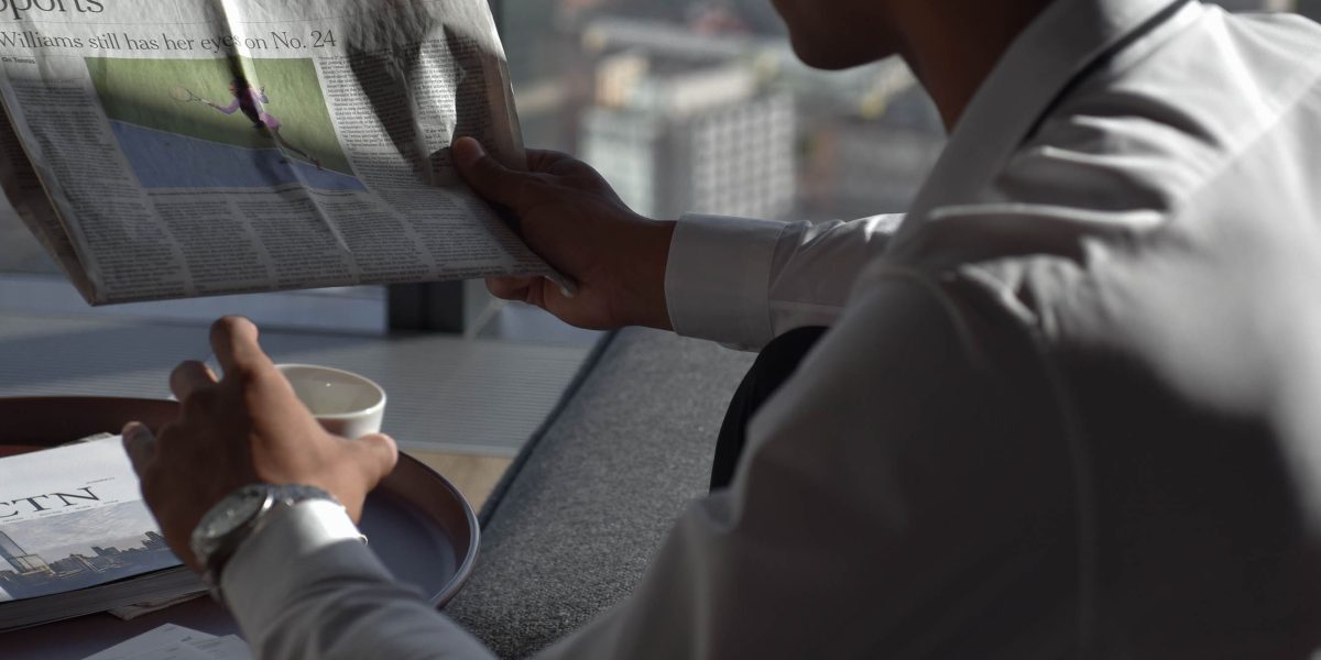 A person intently reviewing documents, symbolizing the challenge business leaders face in staying updated on rapidly changing tech policies.